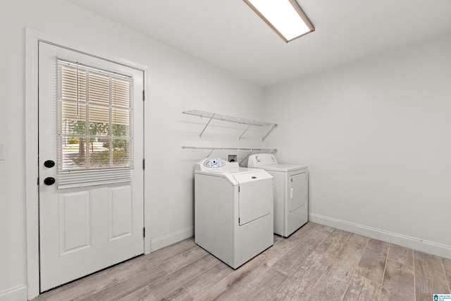 clothes washing area featuring light hardwood / wood-style floors and washer and dryer