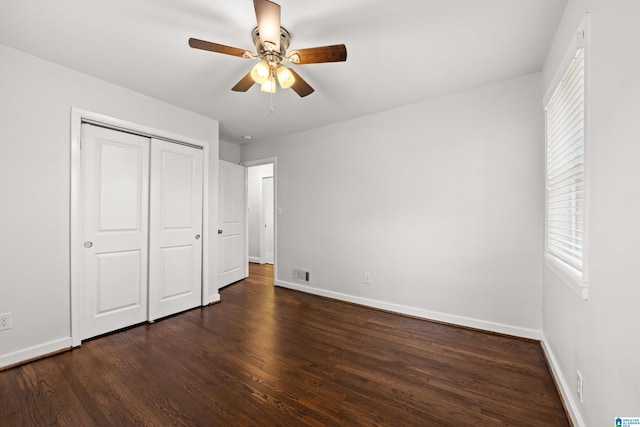 unfurnished bedroom featuring ceiling fan, dark hardwood / wood-style flooring, and a closet