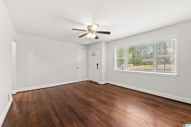 empty room featuring dark wood-type flooring and ceiling fan