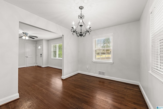 spare room with dark hardwood / wood-style floors and ceiling fan with notable chandelier