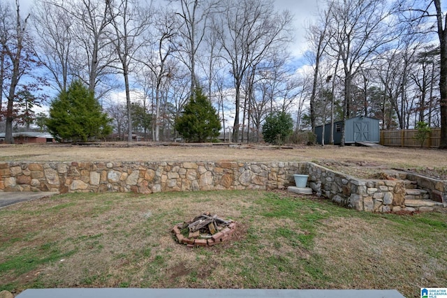 view of yard with a shed and a fire pit