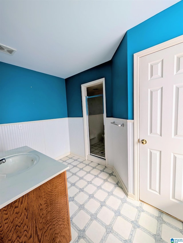 bathroom with wainscoting, visible vents, and tile patterned floors