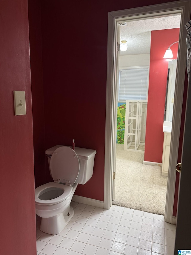 bathroom with tile patterned flooring, a textured ceiling, and toilet