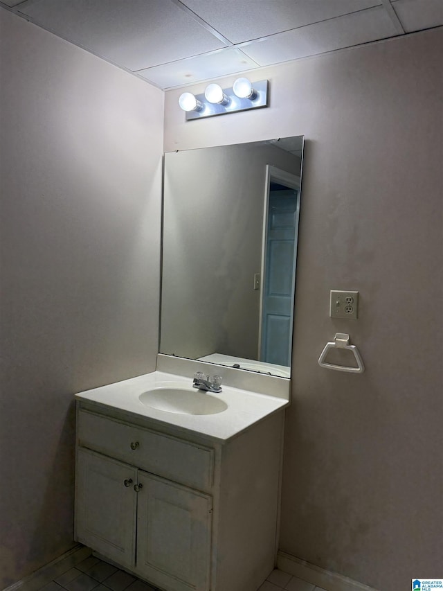 bathroom featuring vanity, a drop ceiling, and tile patterned floors