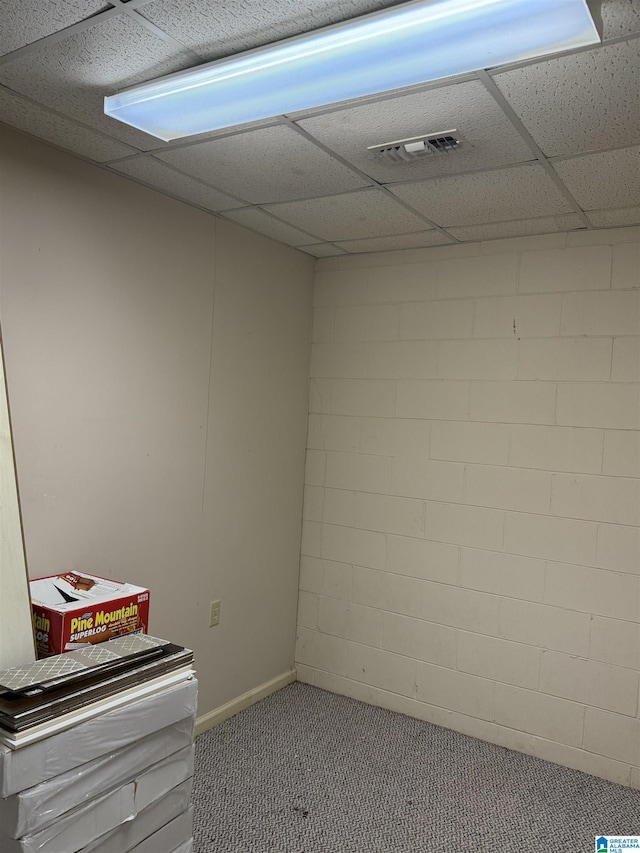 carpeted empty room with a paneled ceiling