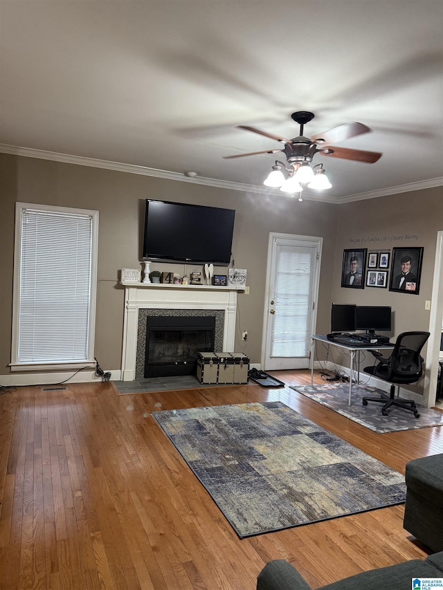 unfurnished living room featuring hardwood / wood-style flooring, ceiling fan, a premium fireplace, and crown molding