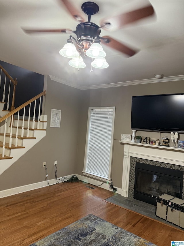 unfurnished living room with hardwood / wood-style flooring, a fireplace, ornamental molding, and ceiling fan