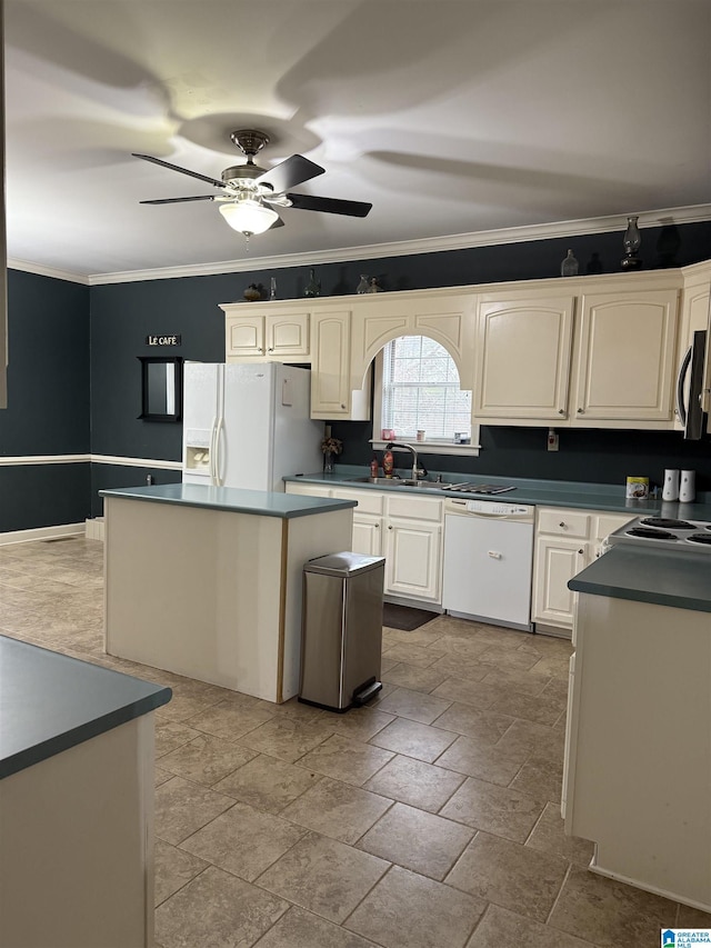 kitchen featuring crown molding, white appliances, sink, and a kitchen island