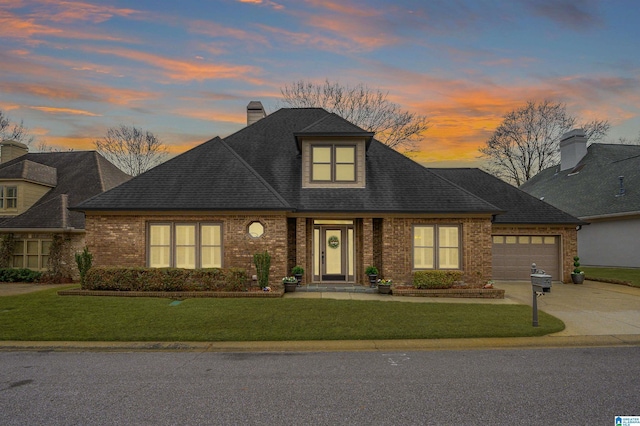 view of front of property with a garage and a lawn