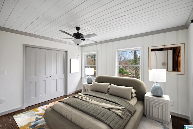 bedroom with dark wood-type flooring, crown molding, wooden ceiling, a closet, and ceiling fan