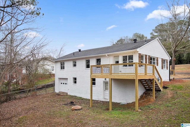 back of property featuring a garage and a deck