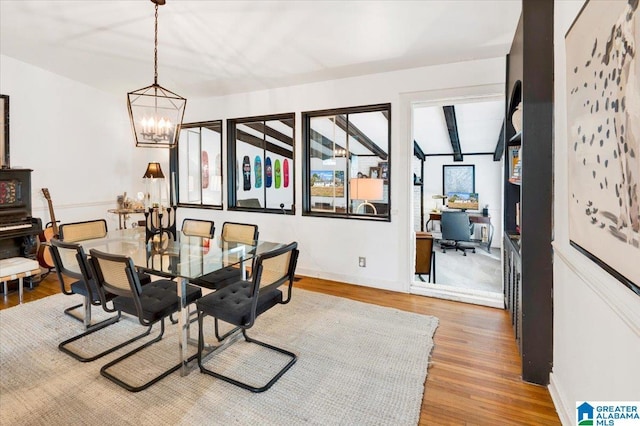 dining room featuring baseboards, wood finished floors, and a notable chandelier