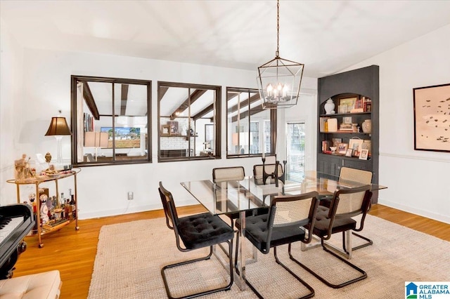 dining space featuring baseboards, an inviting chandelier, and wood finished floors