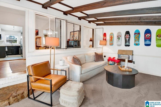 living area featuring wainscoting and beamed ceiling