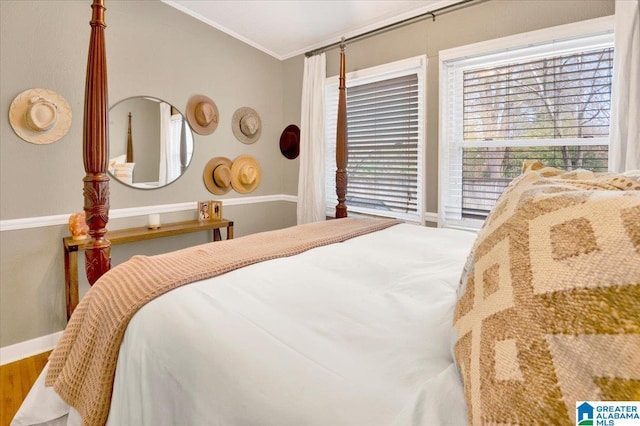 bedroom with ornamental molding, baseboards, and wood finished floors