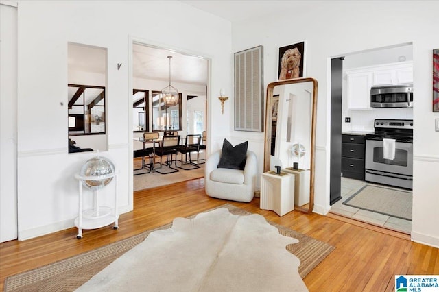 sitting room featuring light wood finished floors and a notable chandelier