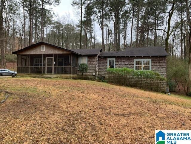 ranch-style home with a front lawn and a sunroom