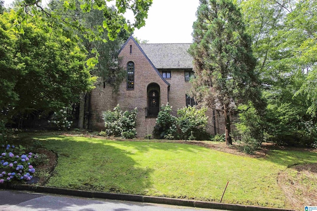 tudor-style house with a front yard