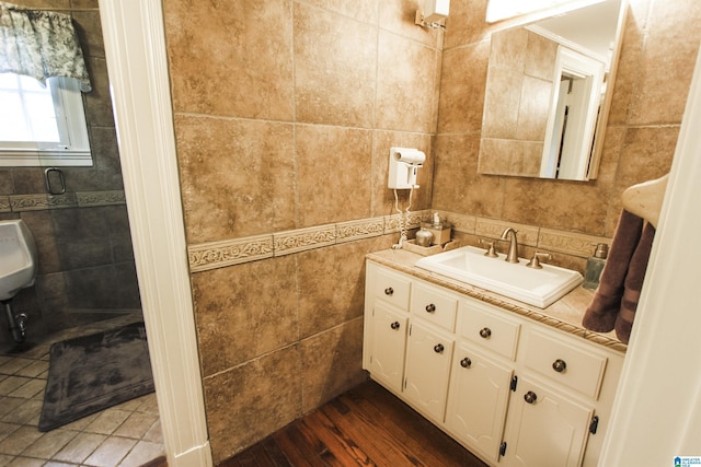 bathroom with hardwood / wood-style floors, vanity, and tile walls