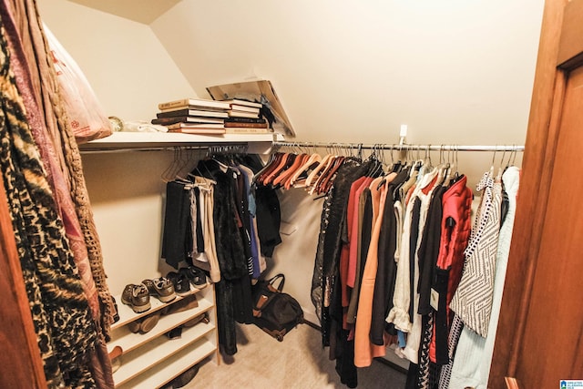 spacious closet with vaulted ceiling and carpet floors