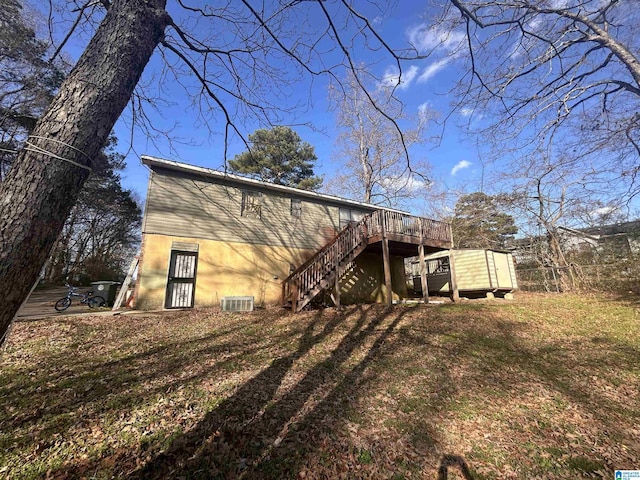 back of property with a wooden deck and a lawn