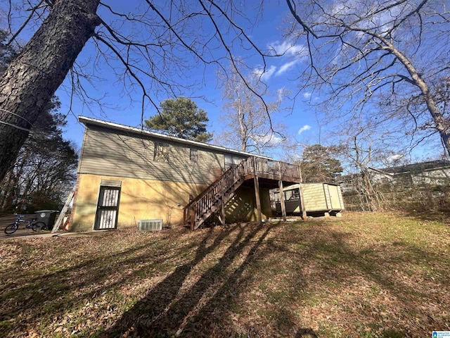 back of house featuring a wooden deck, a lawn, and central air condition unit