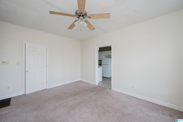 spare room with ceiling fan and light carpet