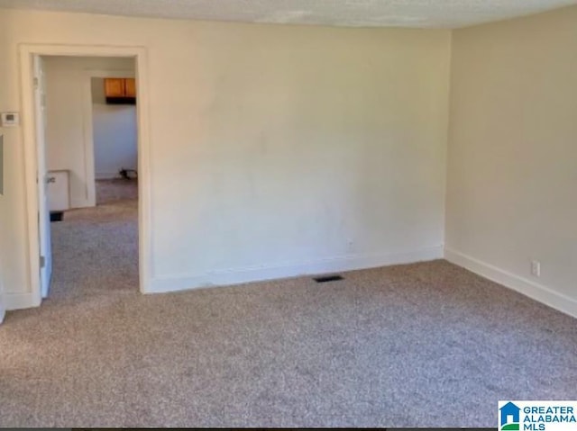 carpeted spare room featuring a textured ceiling