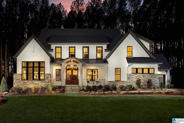 view of front of home featuring french doors and a yard