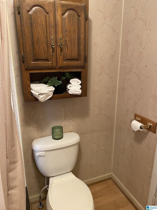 bathroom featuring wood-type flooring and toilet