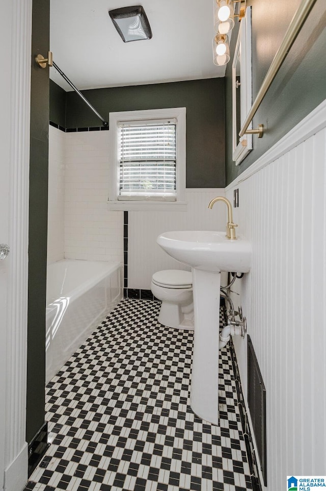 bathroom featuring shower / washtub combination and toilet