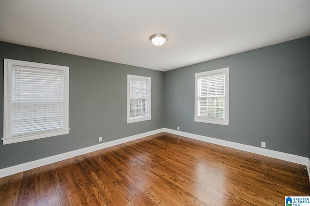 spare room with hardwood / wood-style flooring and a wealth of natural light