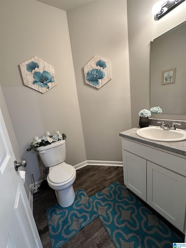 bathroom featuring vanity, hardwood / wood-style floors, and toilet