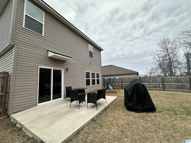 rear view of house with a yard, a patio, and a playground