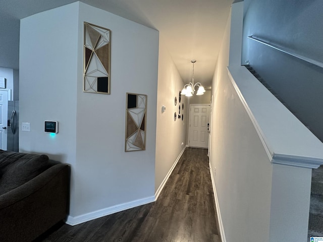 corridor with a notable chandelier and dark hardwood / wood-style flooring