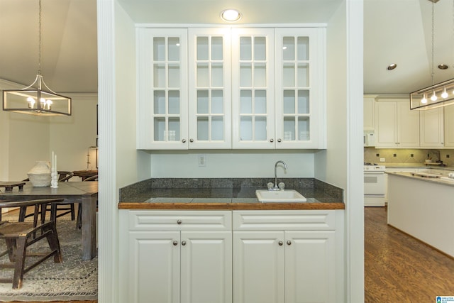 kitchen with sink, white cabinets, white appliances, and decorative light fixtures