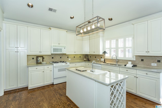 kitchen with white cabinetry, white appliances, a kitchen island with sink, and sink