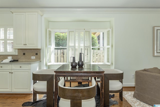 dining room featuring crown molding and light hardwood / wood-style floors