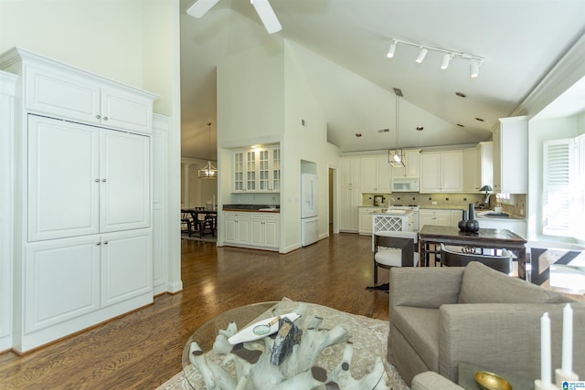 living room with ceiling fan, dark hardwood / wood-style flooring, and high vaulted ceiling