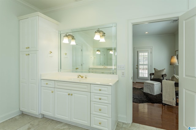 bathroom featuring hardwood / wood-style flooring, ornamental molding, and vanity