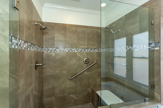 bathroom with ornamental molding and tiled shower