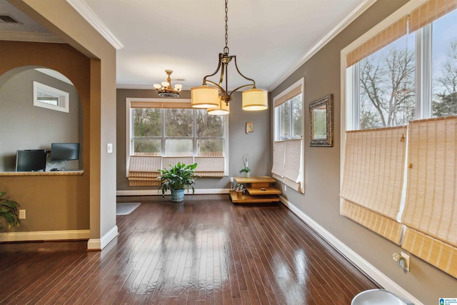 dining area with an inviting chandelier, dark wood-type flooring, and ornamental molding