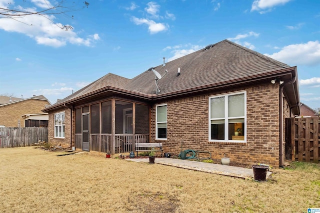 back of property featuring a patio, a sunroom, and a lawn