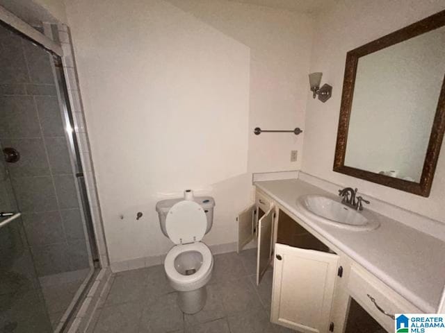 bathroom with vanity, tile patterned floors, toilet, and walk in shower