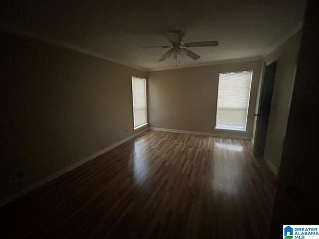 unfurnished room featuring dark hardwood / wood-style flooring, ornamental molding, and ceiling fan