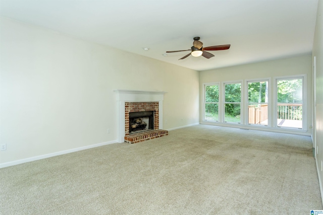 unfurnished living room with a brick fireplace, light carpet, and ceiling fan