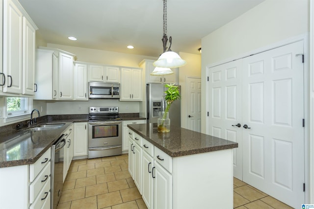 kitchen featuring stainless steel appliances, a center island, sink, and white cabinets