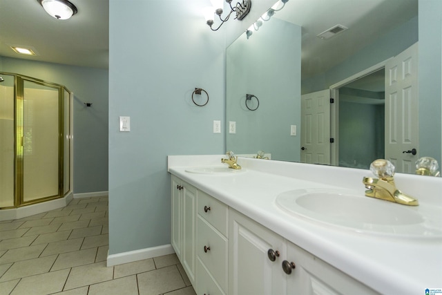 bathroom with an enclosed shower, vanity, and tile patterned floors