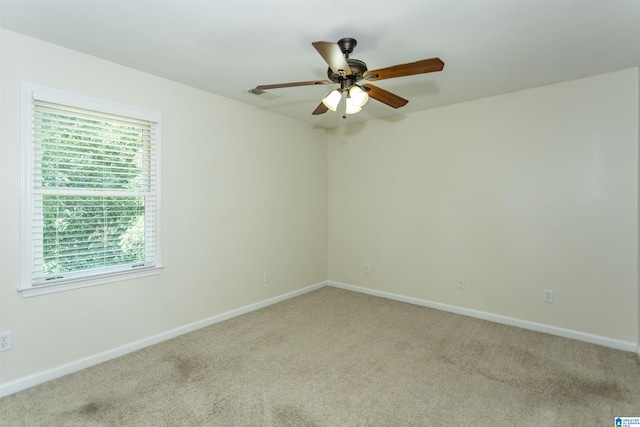 spare room with ceiling fan and light colored carpet