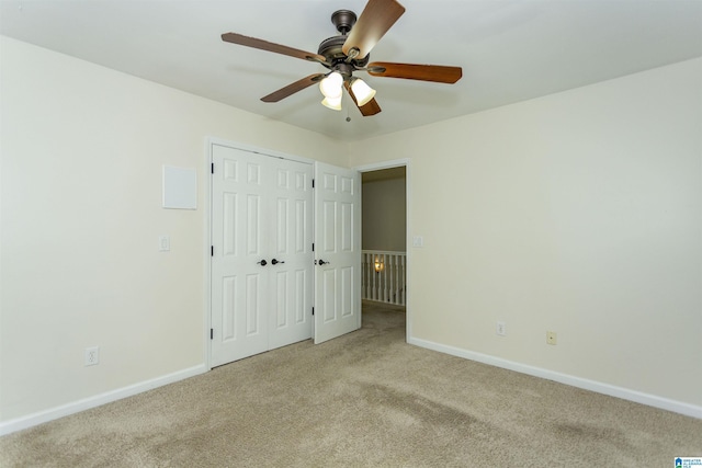 unfurnished bedroom with light carpet, ceiling fan, and a closet